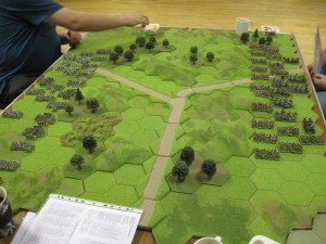 Andre's terrain layout, with the Y shaped road and a scattering of hills and forests and a 4-hex area of broken ground on the left.